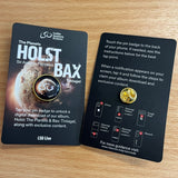 Two "Holst / Bax - Pin badge download" cards by LSO Live lie on wood. The left card promotes the digital album; the right card explains how to access it using the metal pin badge.